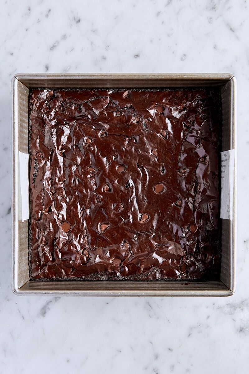 Baked cocoa brownies in parchment-lined pan