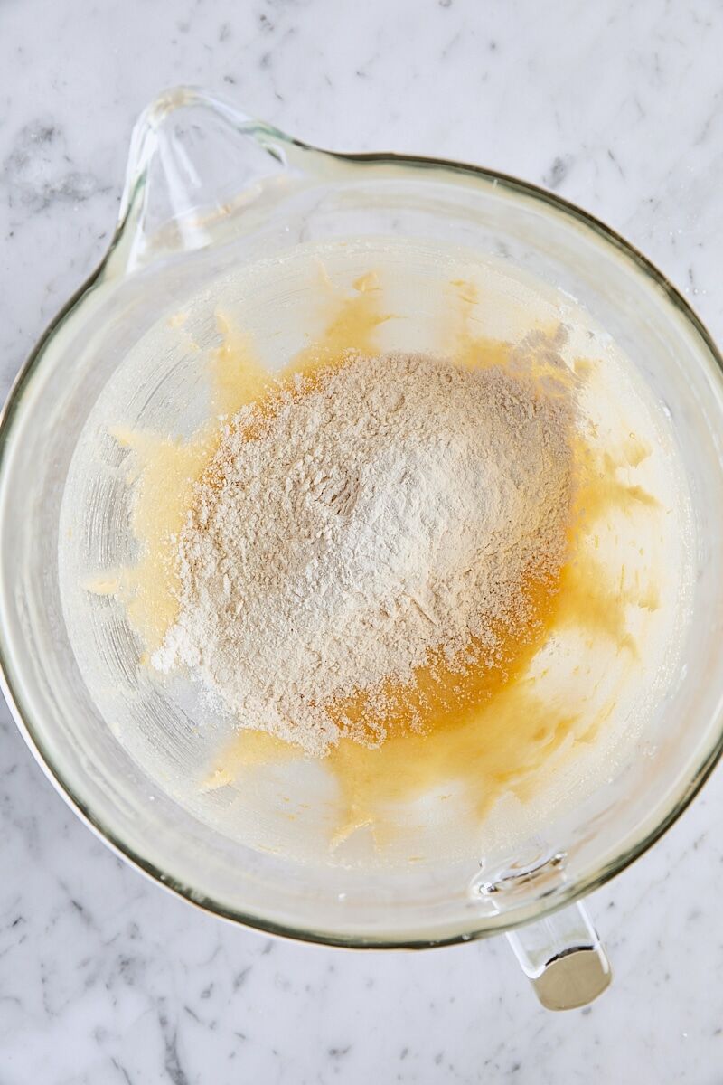 Dry ingredients added to batter in glass mixer bowl