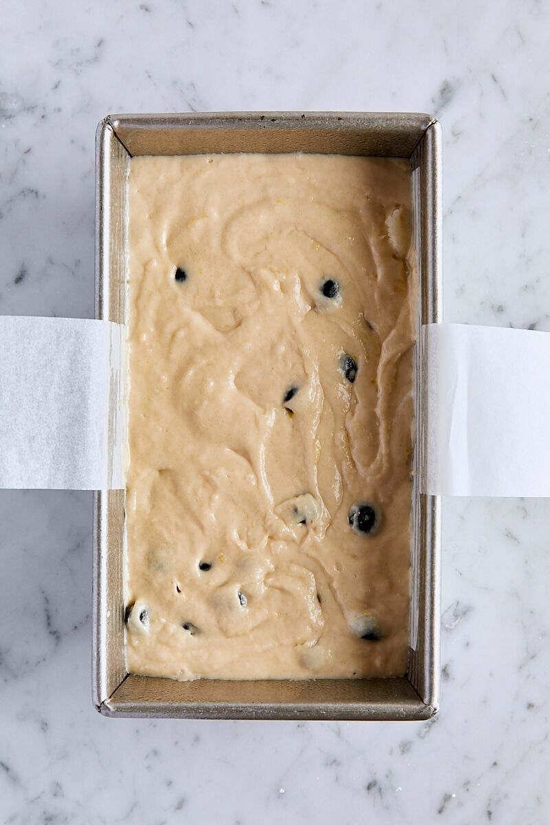 Blueberry loaf cake batter in parchment-lined loaf pan