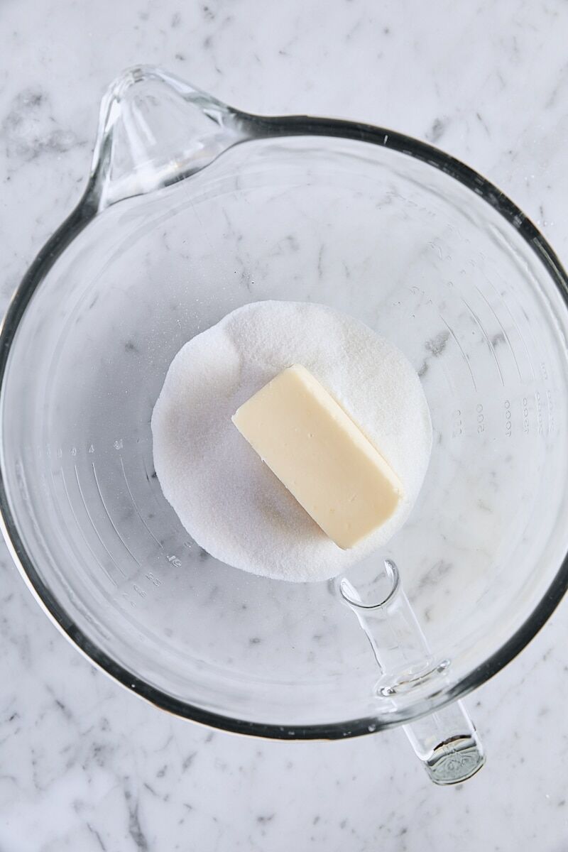 Room temperature butter and sugar in glass mixer bowl