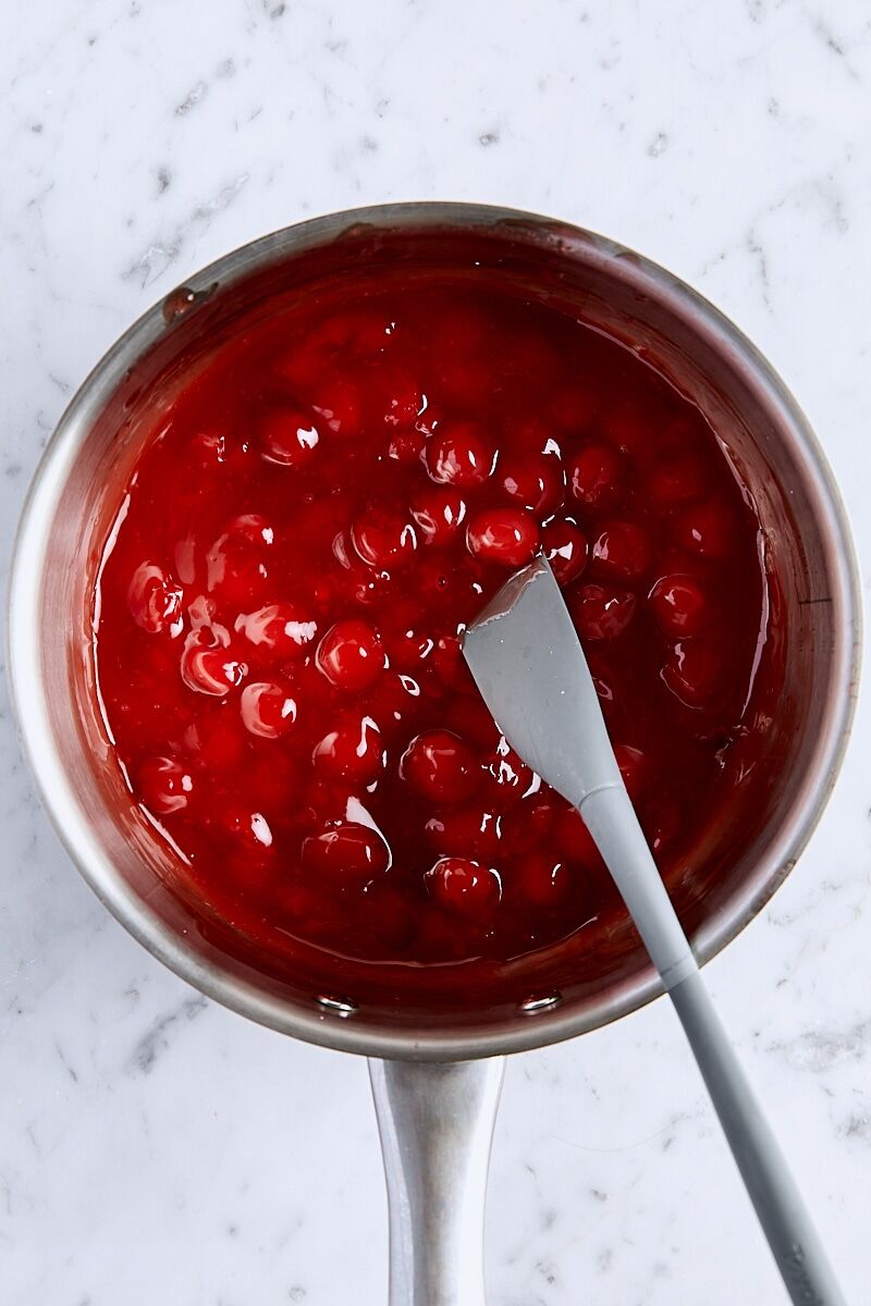 Cooked cherry filling in saucepan with small spatula