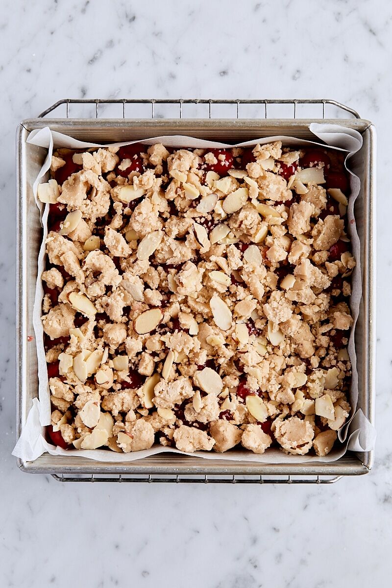 Crumble topping sprinkled over cherry filling