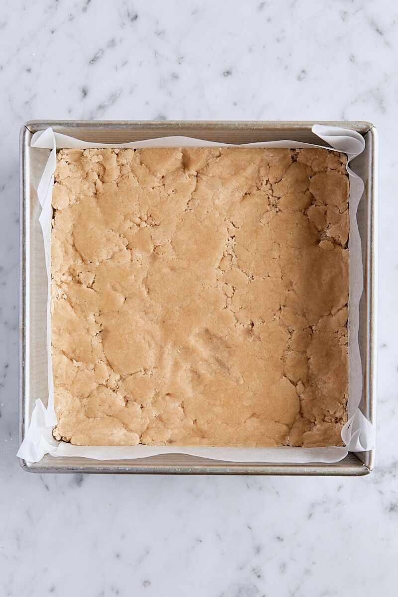 Crust mixture pressed into parchment-lined square baking pan
