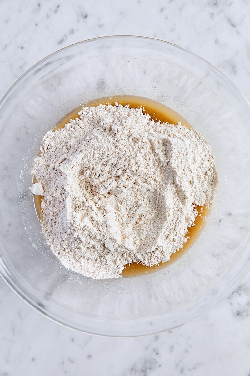 Flour mixture added to melted butter mixture in large glass bowl