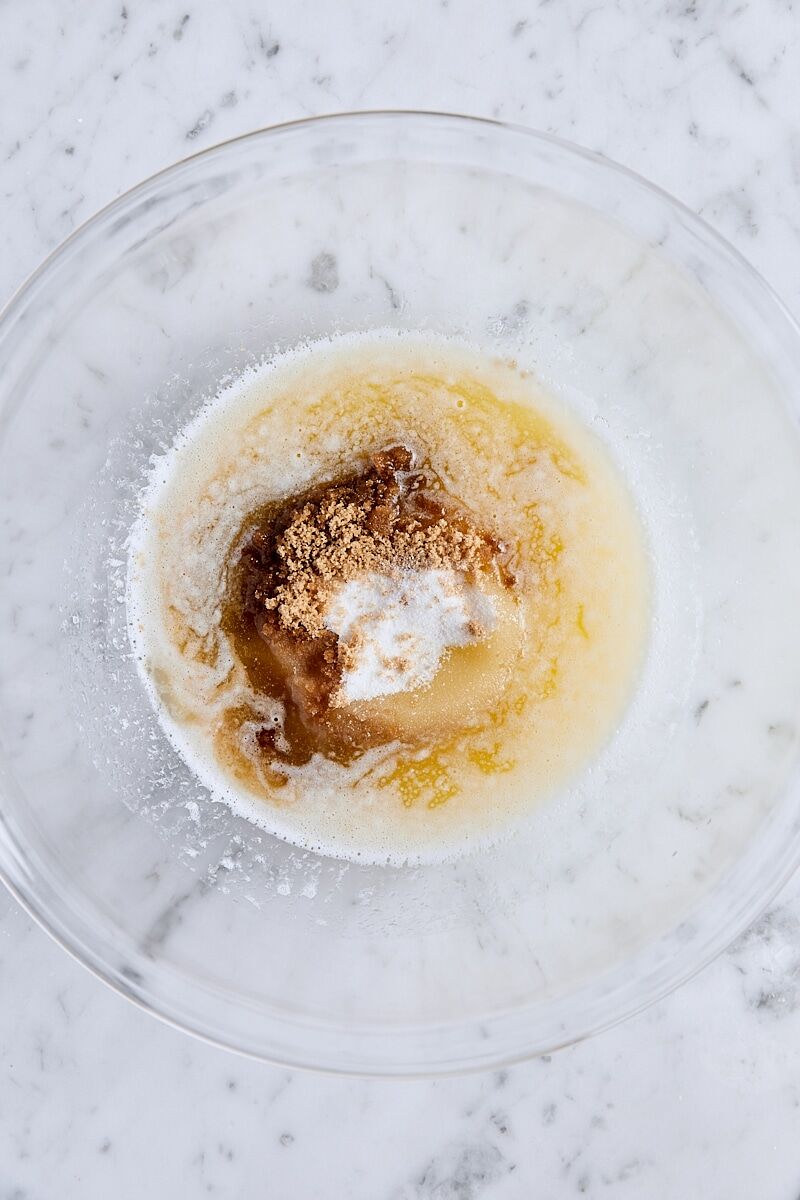 Melted butter, sugar, light brown sugar, vanilla extract, and almond extract in large glass bowl