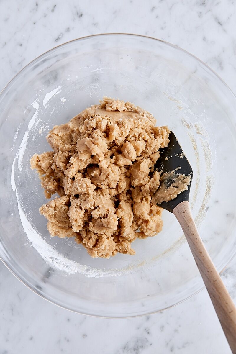 Crust and crumble dough mixed together in large glass bowl with spatula
