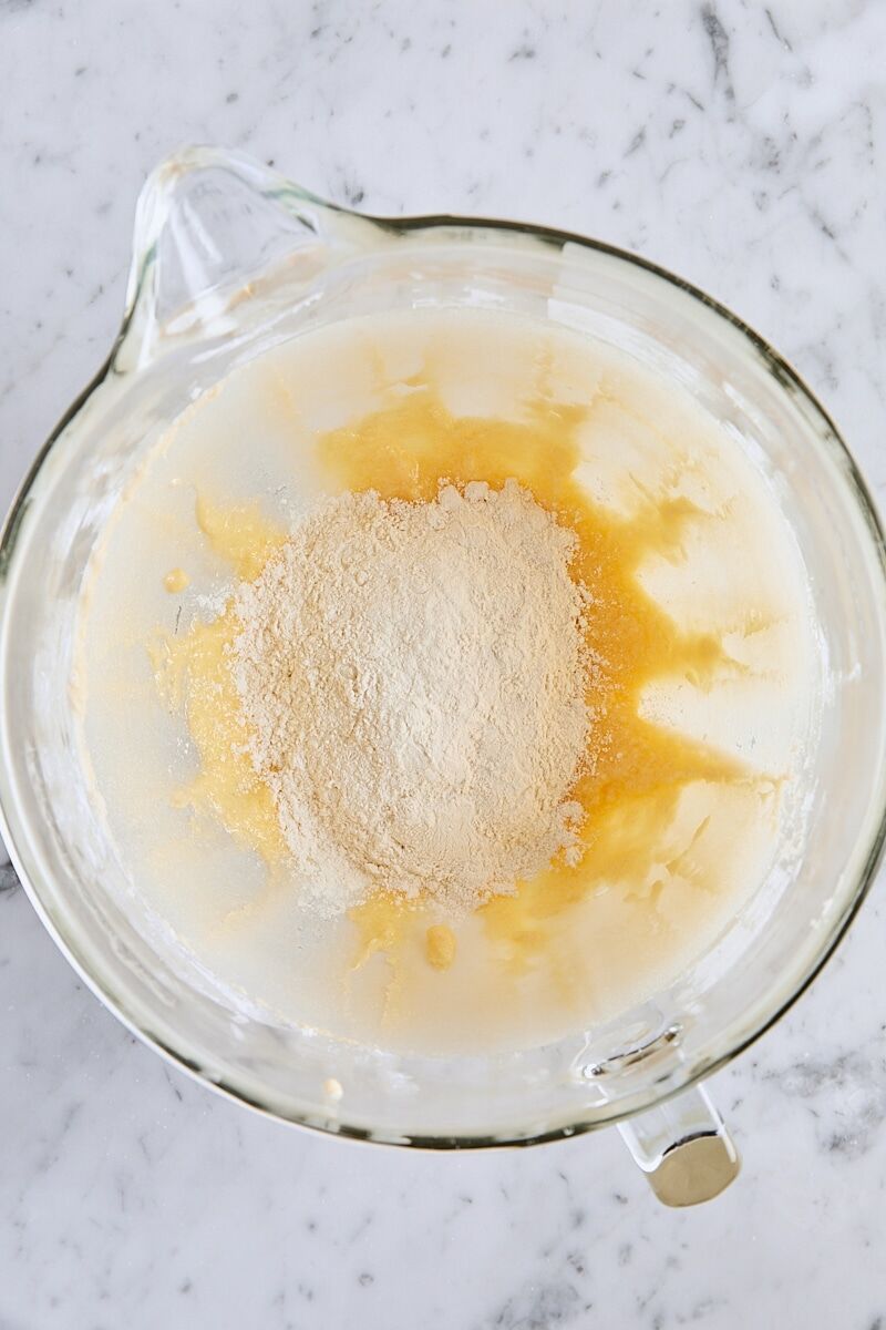 Dry ingredients added to batter in glass mixer bowl