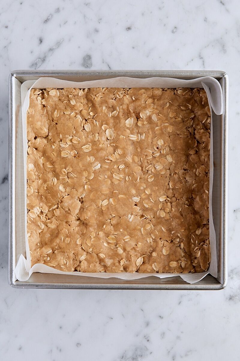 Crust mixture pressed into parchment-lined square baking pan