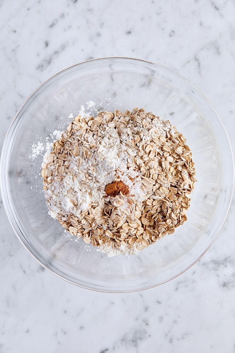 All-purpose flour, rolled oats, baking soda, salt, and cinnamon in glass bowl