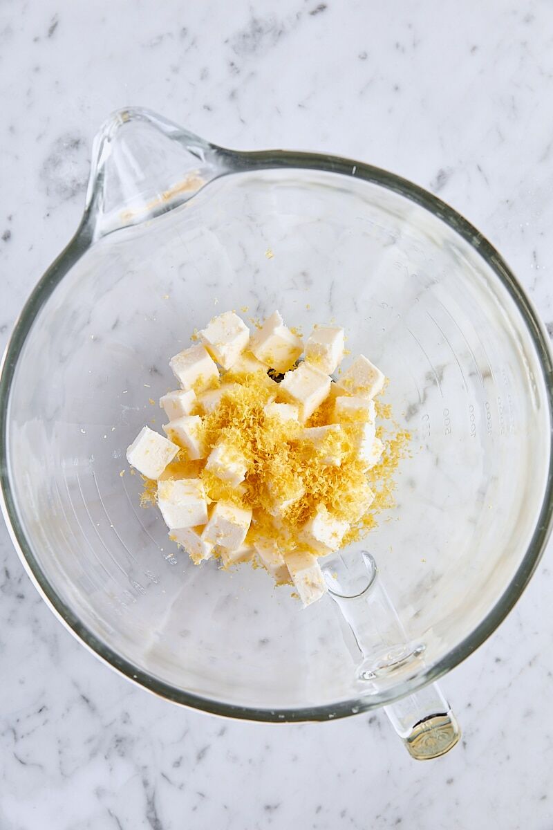 Cubed unsalted butter, salt, and lemon zest in glass mixer bowl