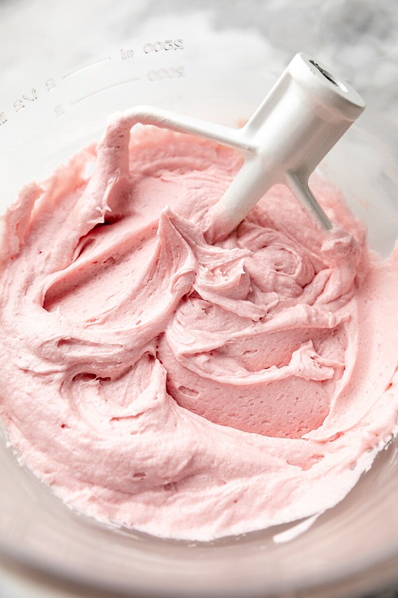 Raspberry frosting in glass mixer bowl with paddle attachment