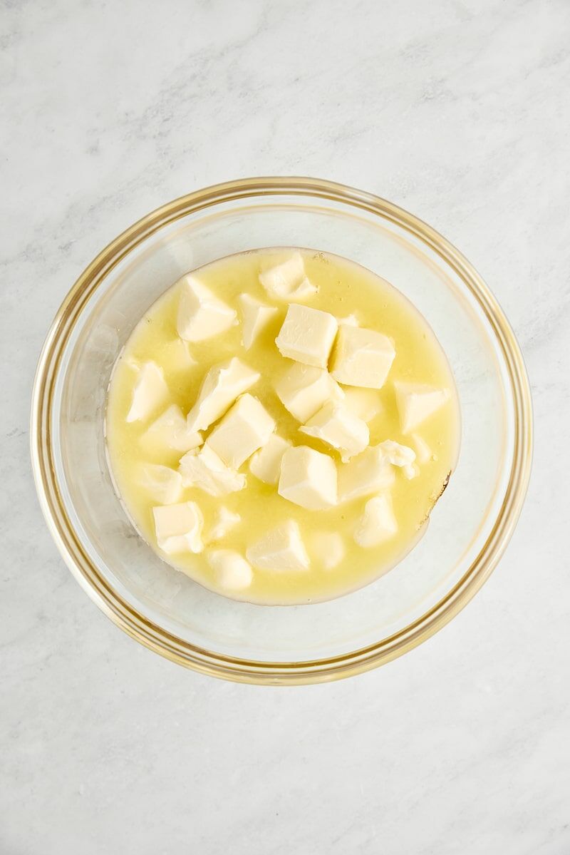 Warm wildflower honey and cubed butter in glass mixing bowl