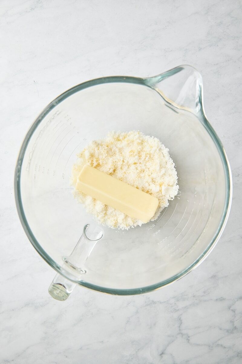 Unsalted butter and lemon-sugar in glass mixer bowl