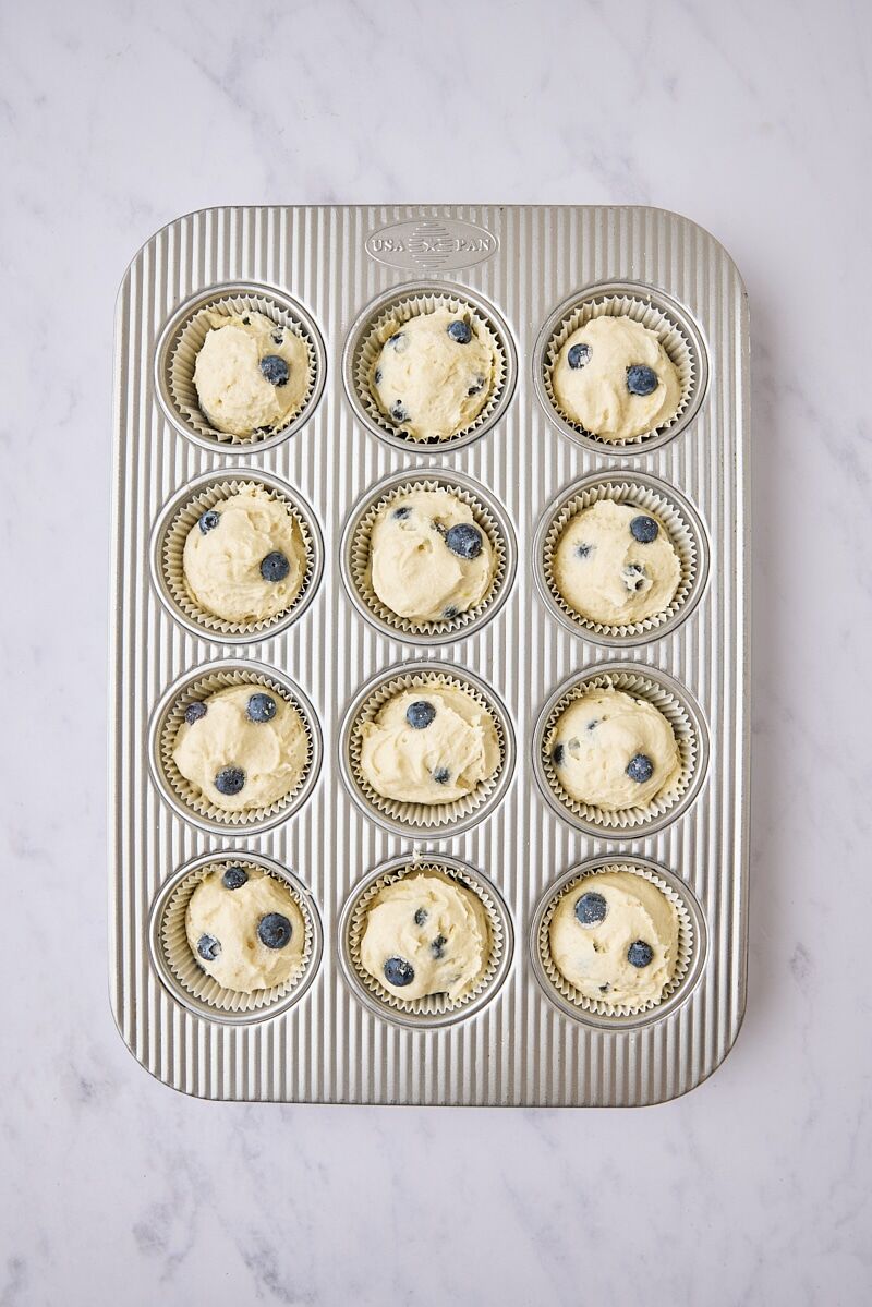 Muffin batter scooped into muffin tin