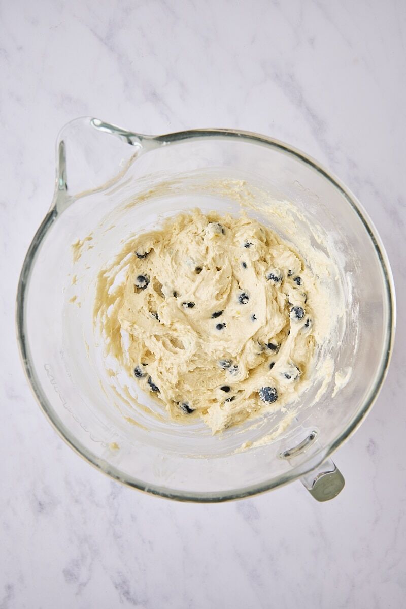 Mixed blueberry muffin batter in glass mixer bowl