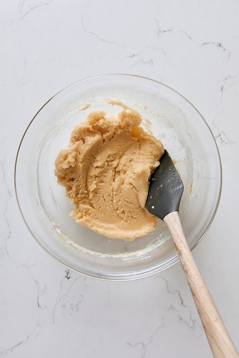 Mixed cobbler topping in glass bowl with spatula