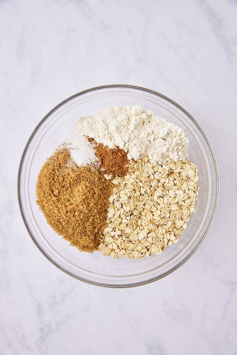 Rolled oats, flour, brown sugar, cinnamon, and salt in glass bowl