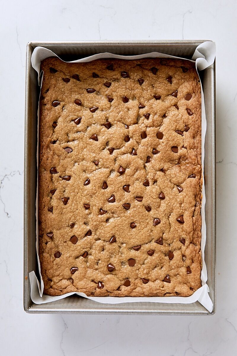 Baked cookie bars in parchment-lined 9 x 13" pan