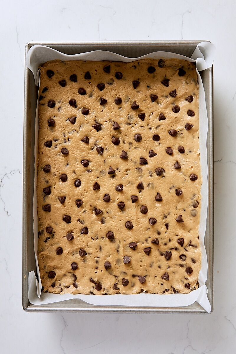 Chocolate chip cookie dough pressed into parchment-lined 9 x 13" pan