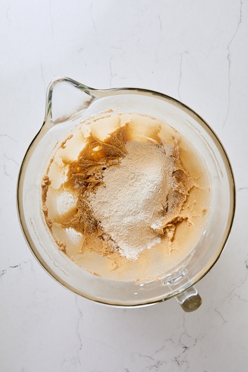 Flour mixture added to dough in glass mixer bowl