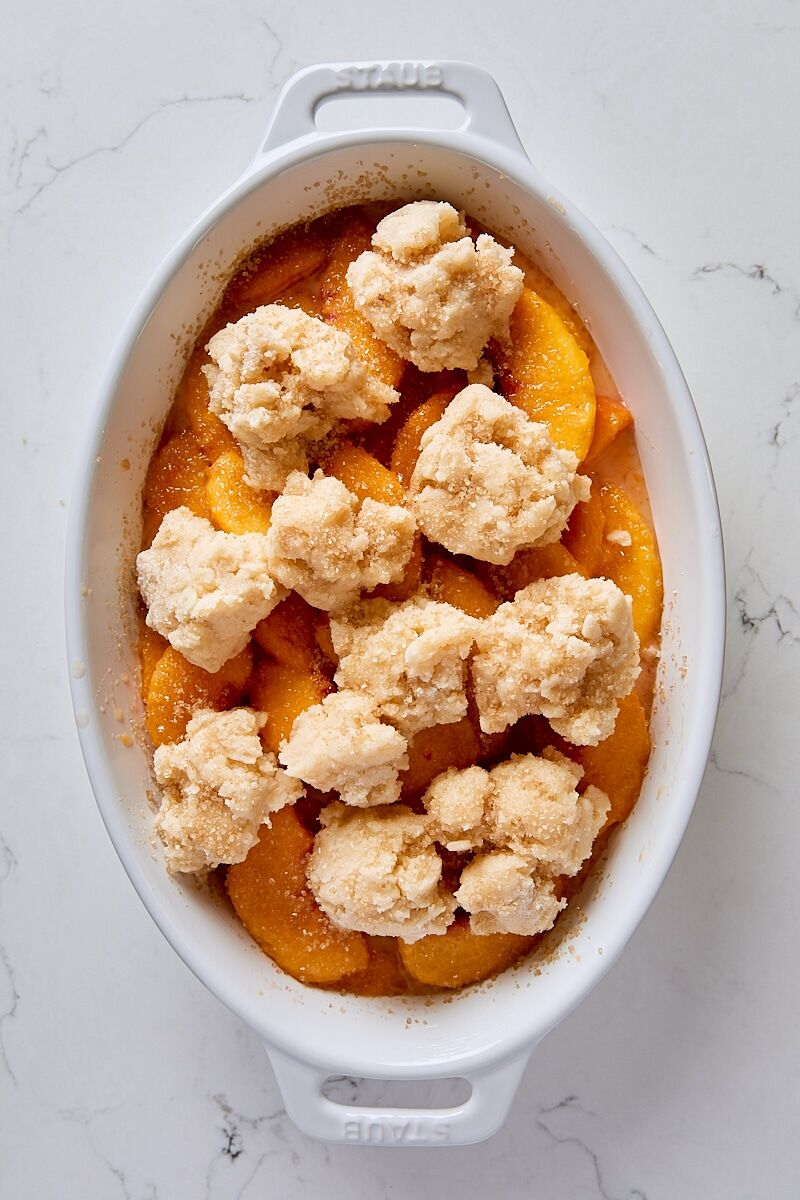 Assembled peach cobbler in baking dish
