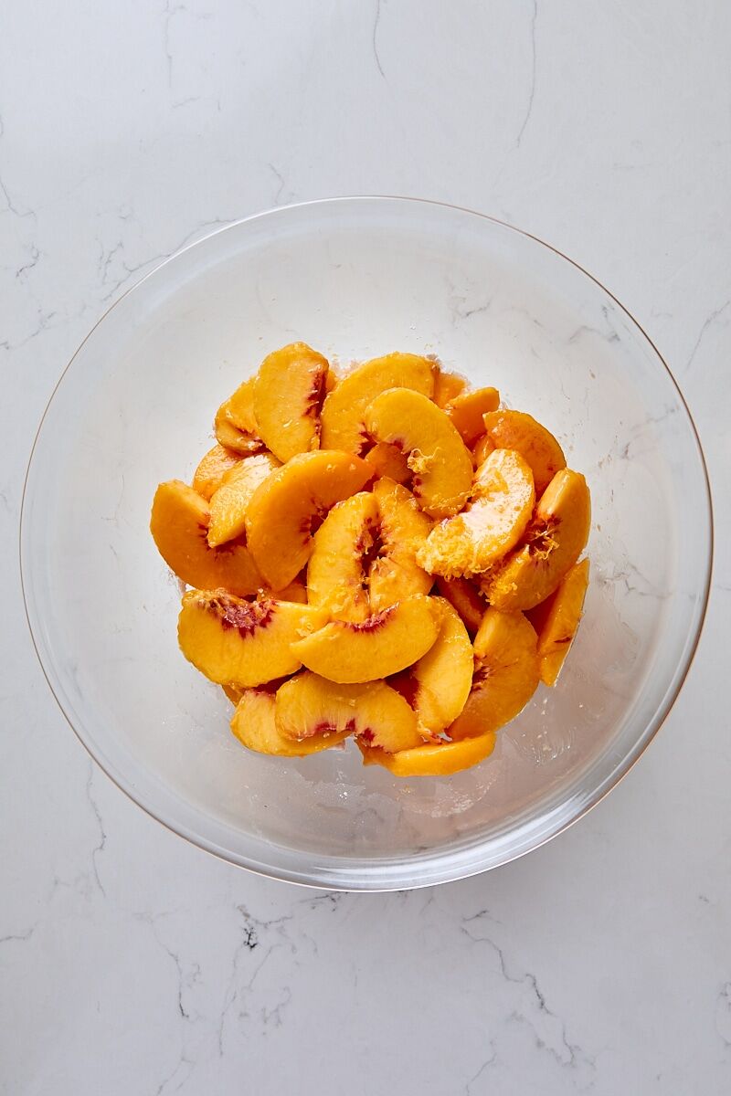 Fresh peach slices, lemon zest, and lemon juice added to sugar mixture