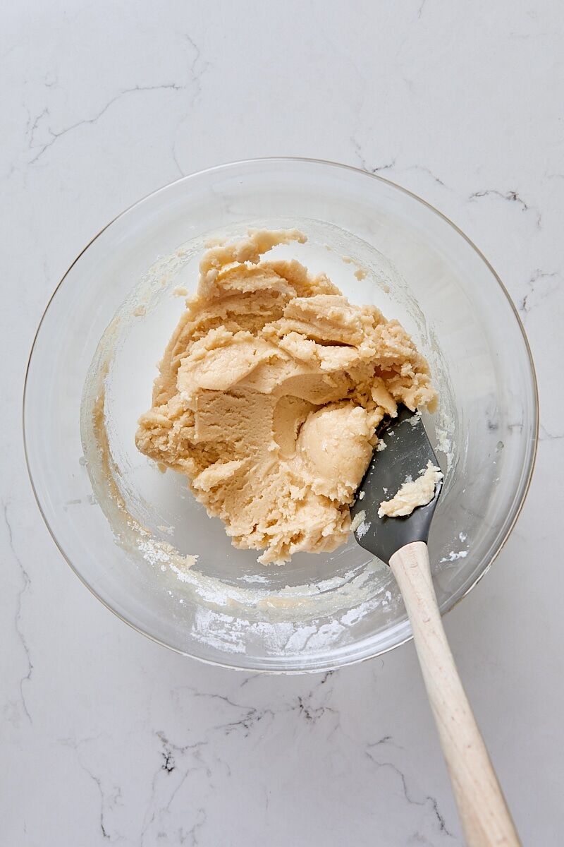 Mixed cobbler topping in glass bowl with spatula