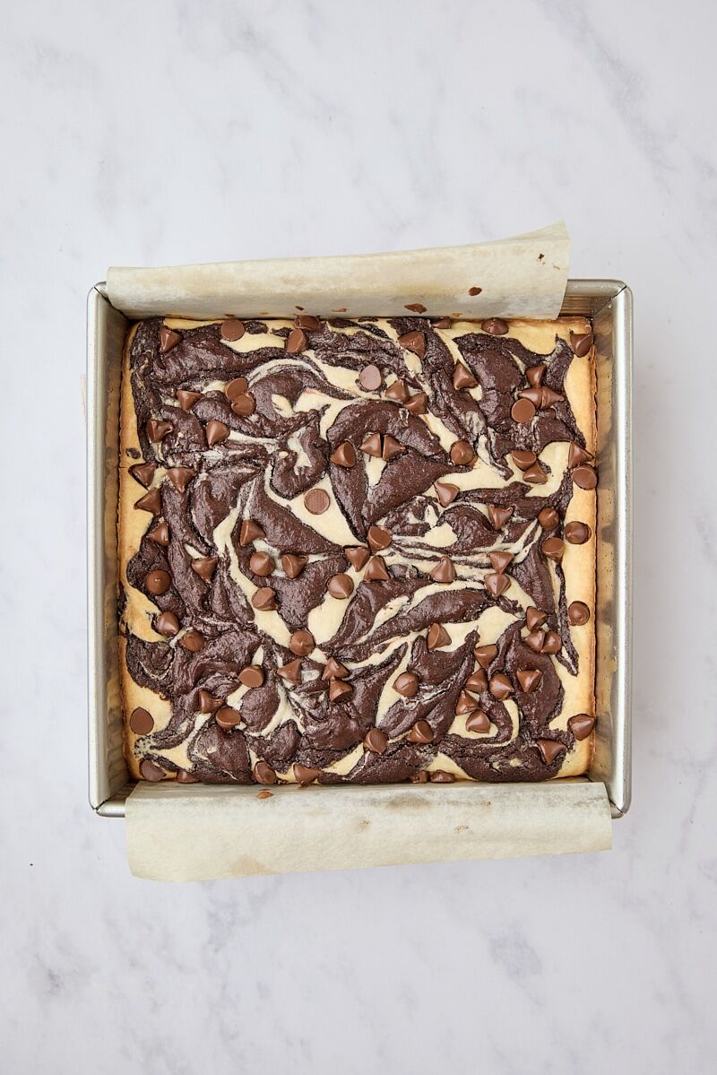 Baked cream cheese brownies in parchment-lined pan