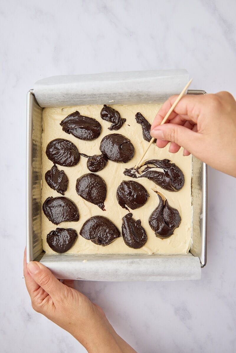 Dollops of brownie batter over cream cheese layer