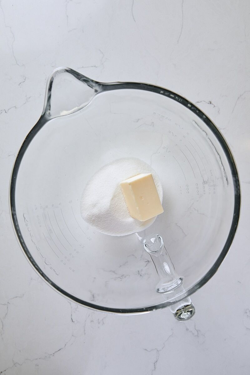 Butter and granulated sugar in glass mixer bowl