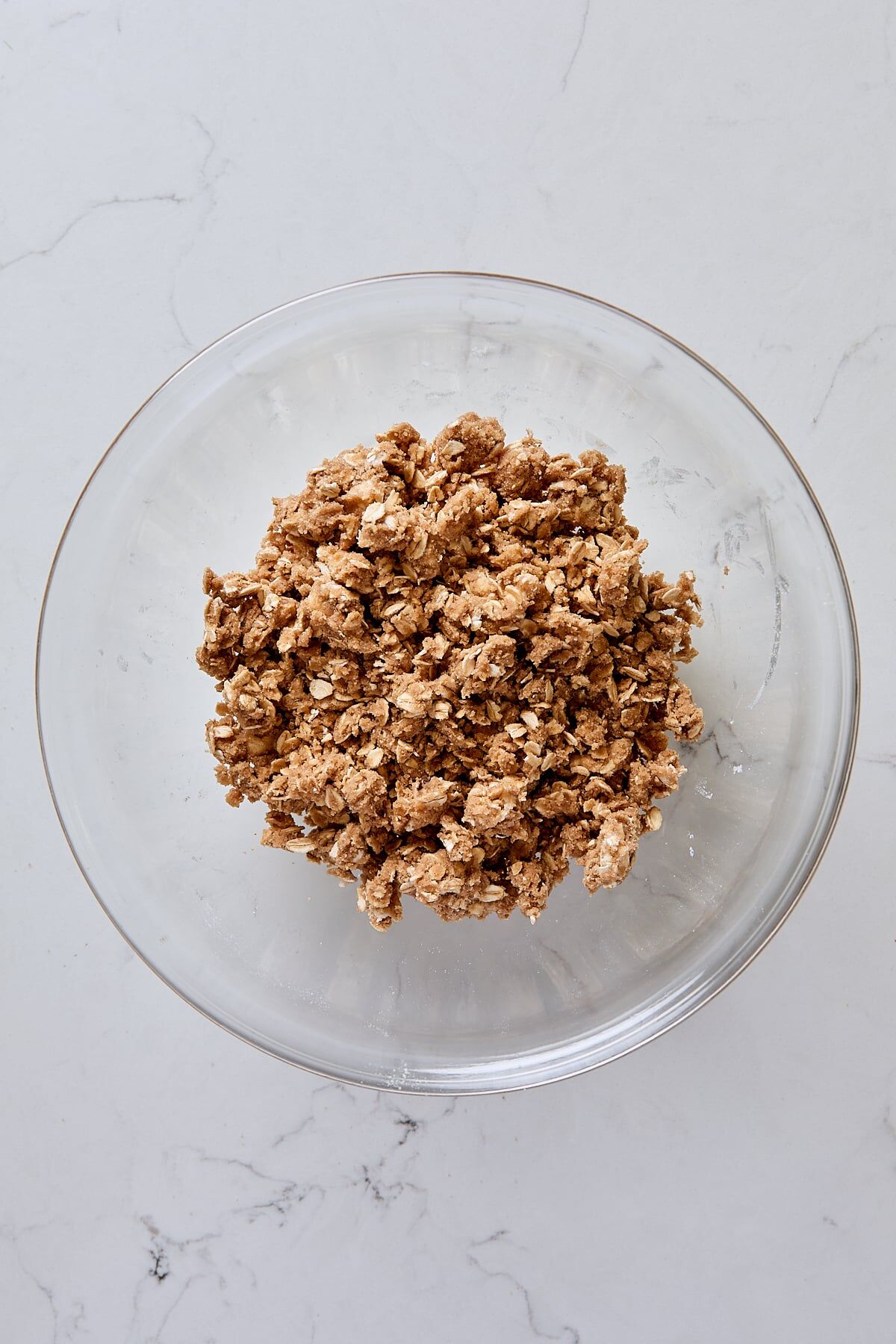 Mixed oatmeal crumble topping in glass bowl