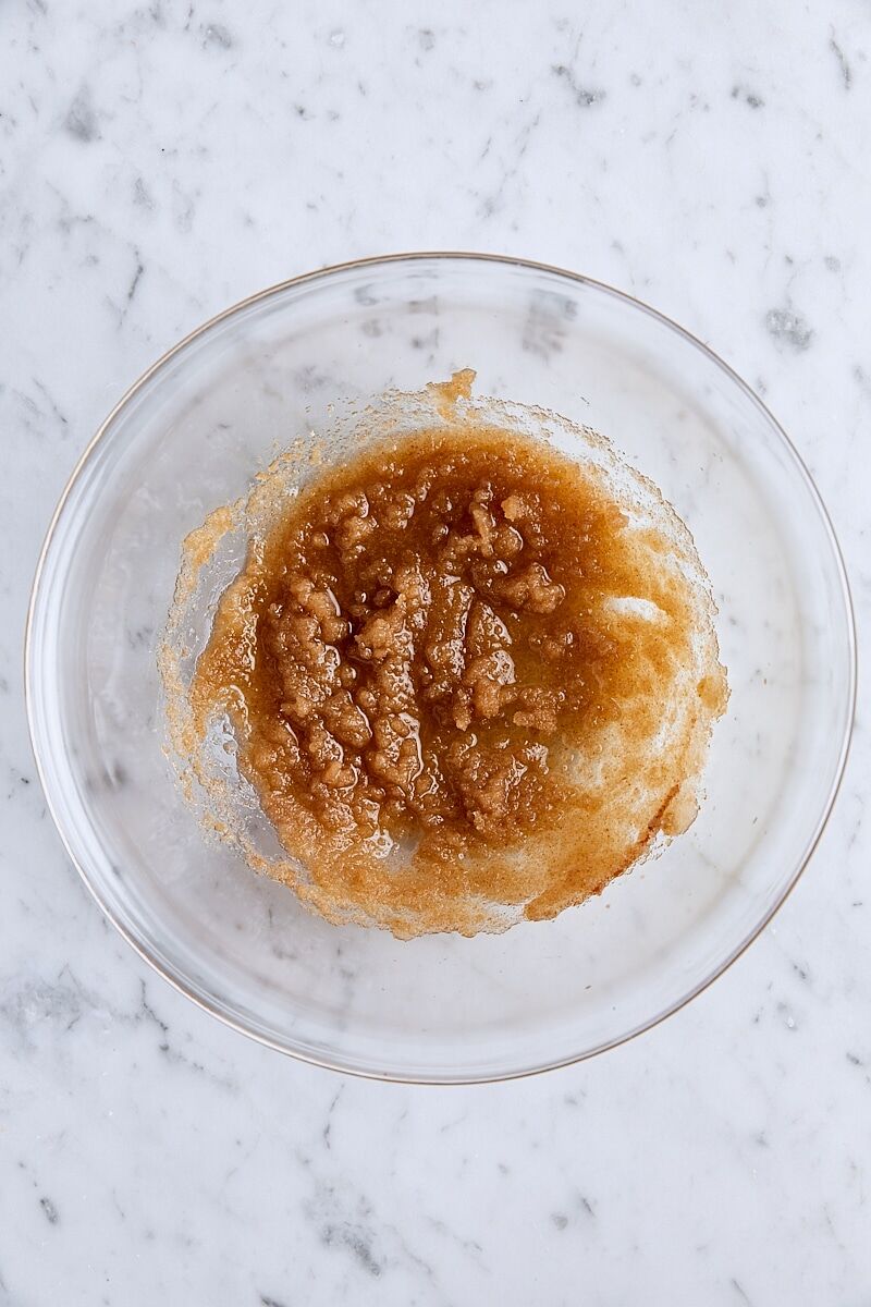 Brown butter and sugars whisked together in glass bowl