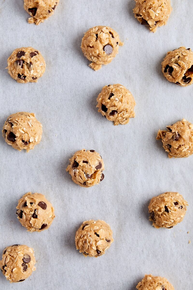 Cookie dough balls scooped onto parchment-lined baking sheet