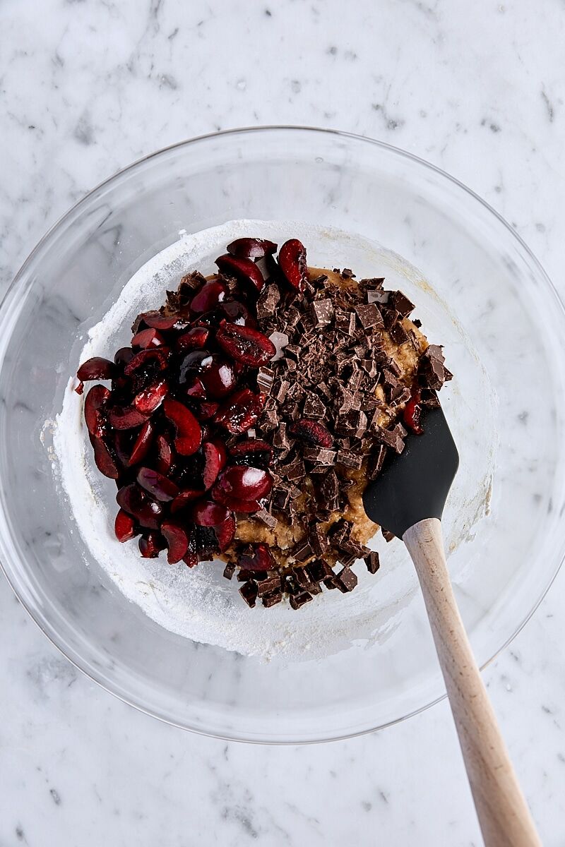 Cherries and semisweet chocolate added to blondie batter in glass bowl