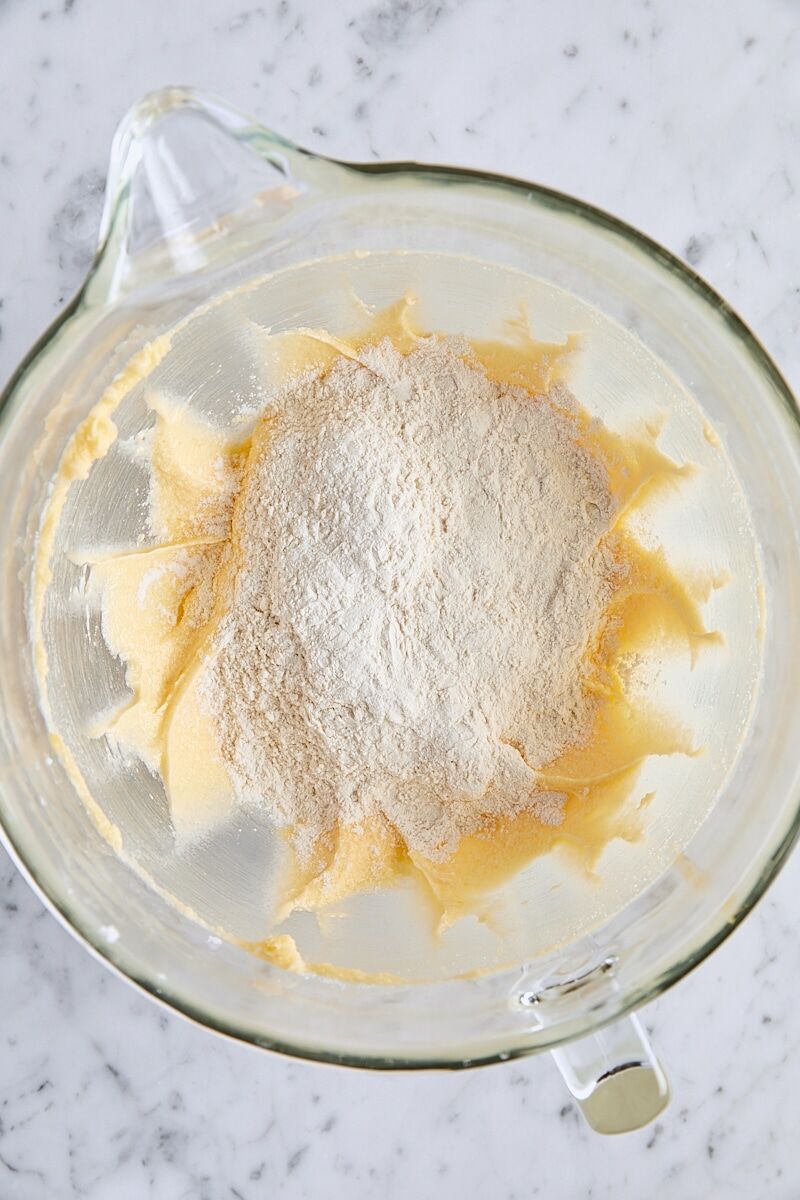 Dry ingredients added to batter in glass mixing bowl