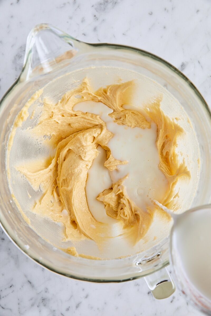 Wet ingredients added to batter in glass mixing bowl