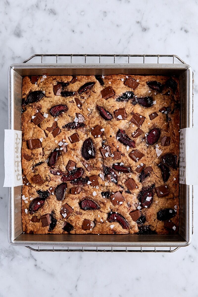 Baked cherry chocolate blondies in parchment-lined square pan