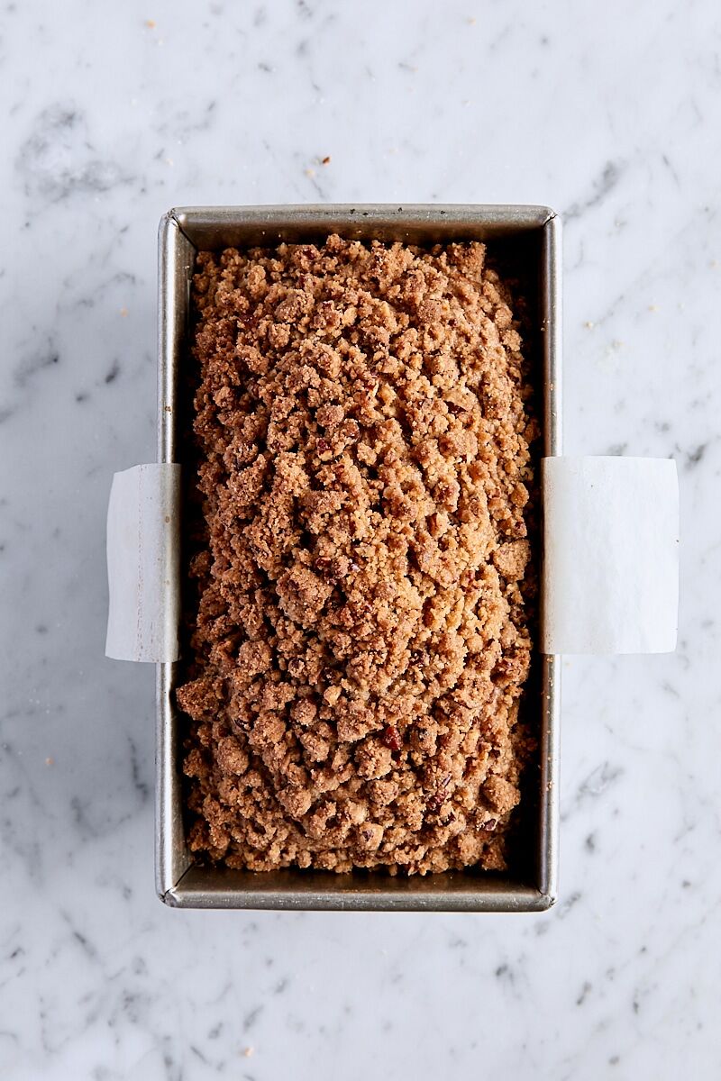 Baked pumpkin streusel bread in parchment-lined loaf pan