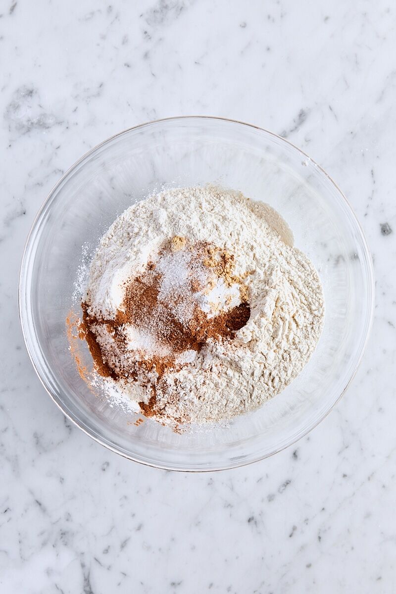 All-purpose flour, cream of tartar, ground cinnamon, ginger, cloves, nutmeg, baking soda, and salt in glass bowl