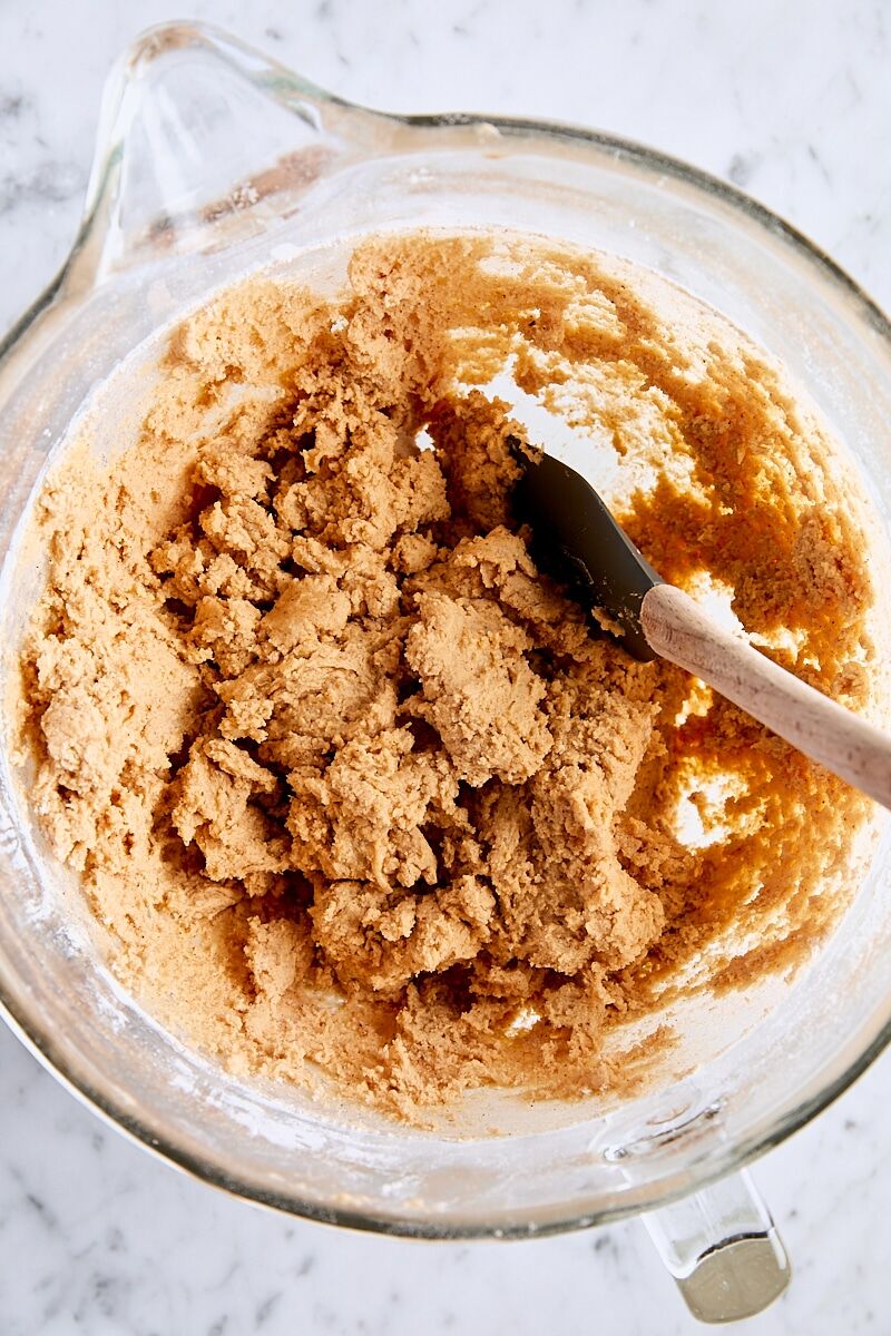 Pumpkin snickerdoodle cookie dough in glass bowl with spatula