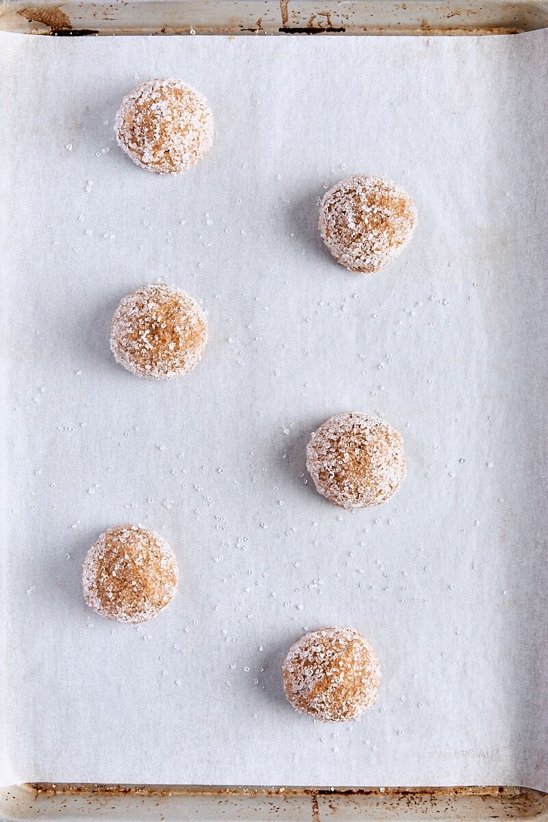 Giant ginger cookie dough balls scooped onto parchment-lined baking sheet