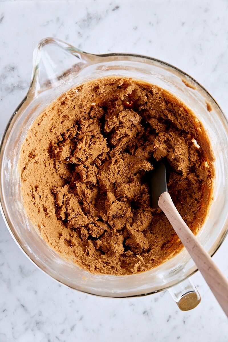 Ginger cookie dough in glass bowl with spatula