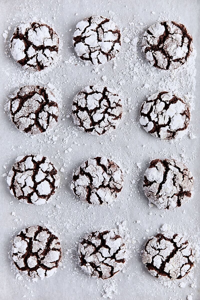 Baked chocolate crinkle cookies on parchment-lined baking sheet