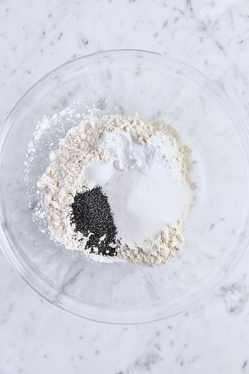 All-purpose flour, granulated sugar, poppy seeds, baking powder, baking soda, and salt in glass bowl