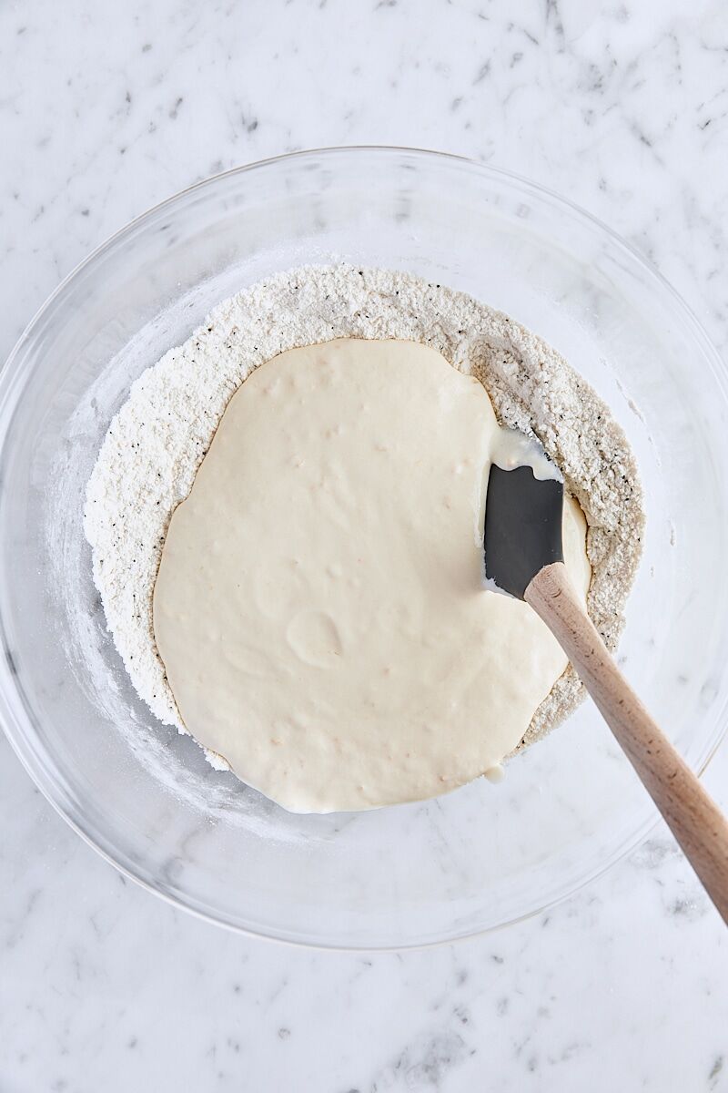 Sour cream mixture added to flour mixture in large glass bowl