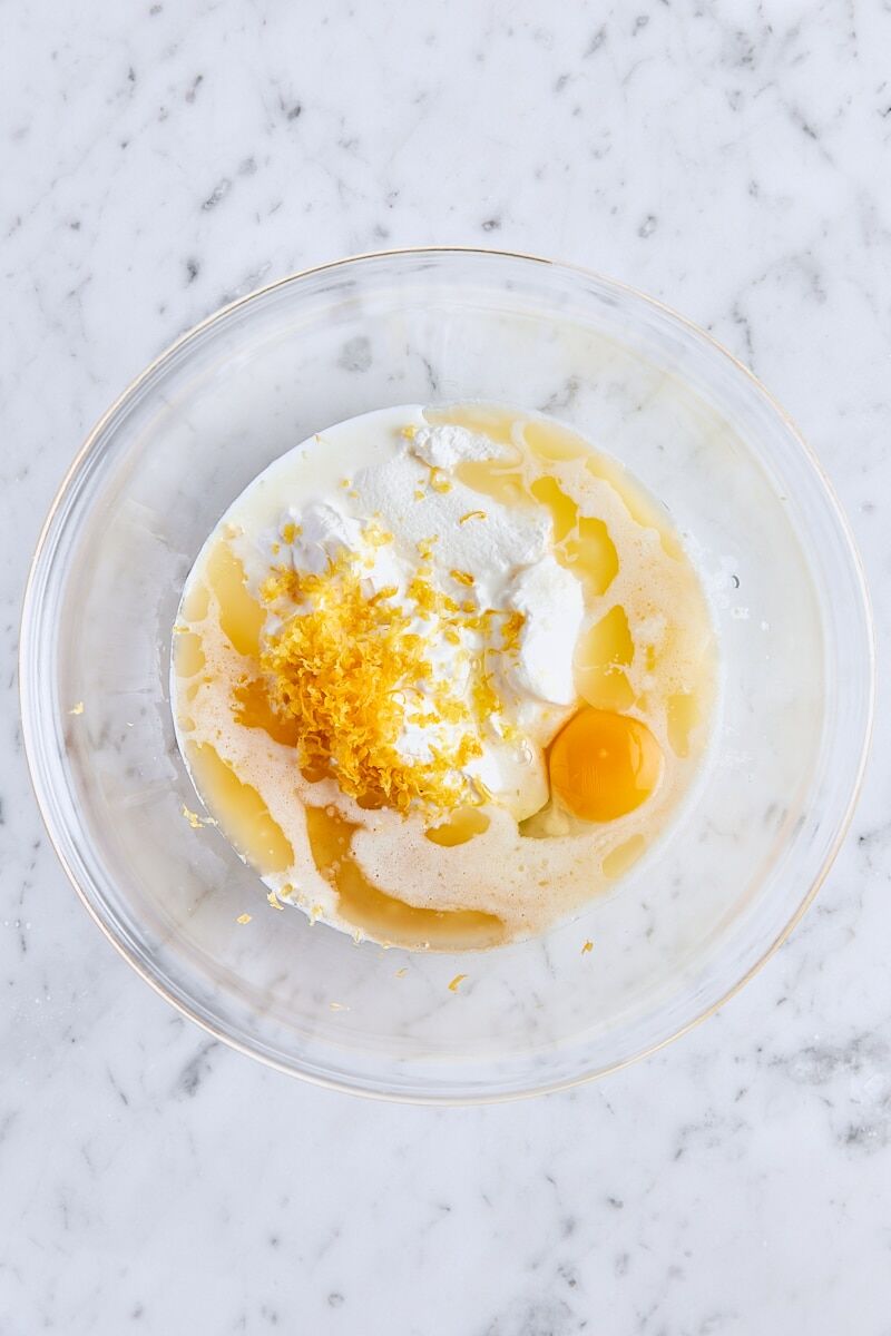 Milk, sour cream, melted butter, egg, lemon zest, and vanilla extract in glass bowl