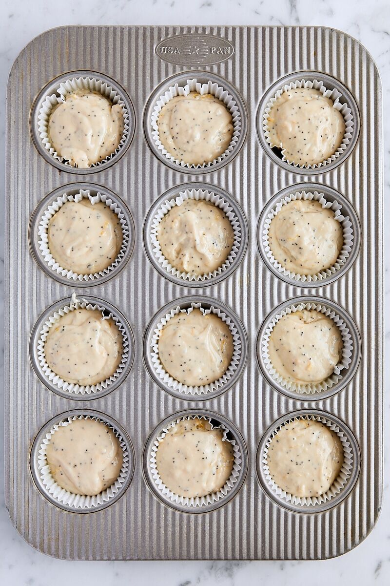 Poppy seed muffin batter scooped into muffin tin