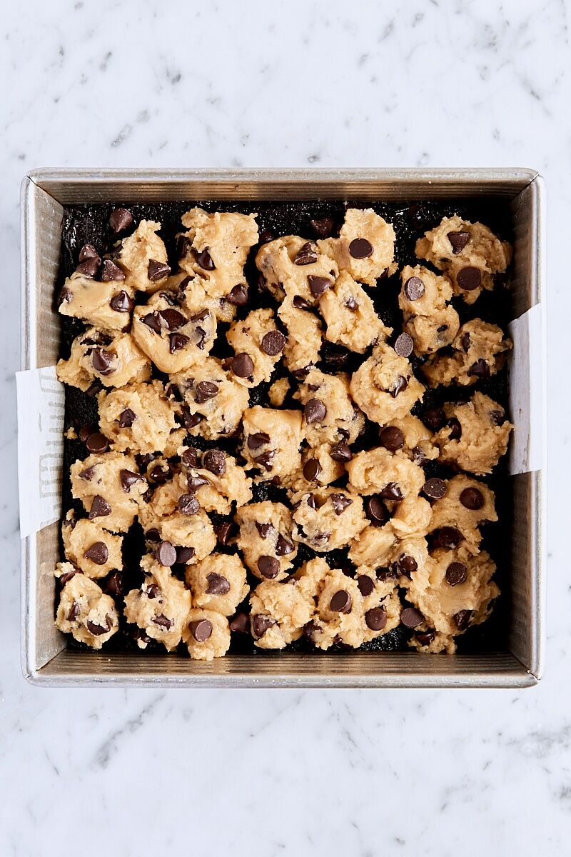 Assembled brookie bars in parchment-lined pan