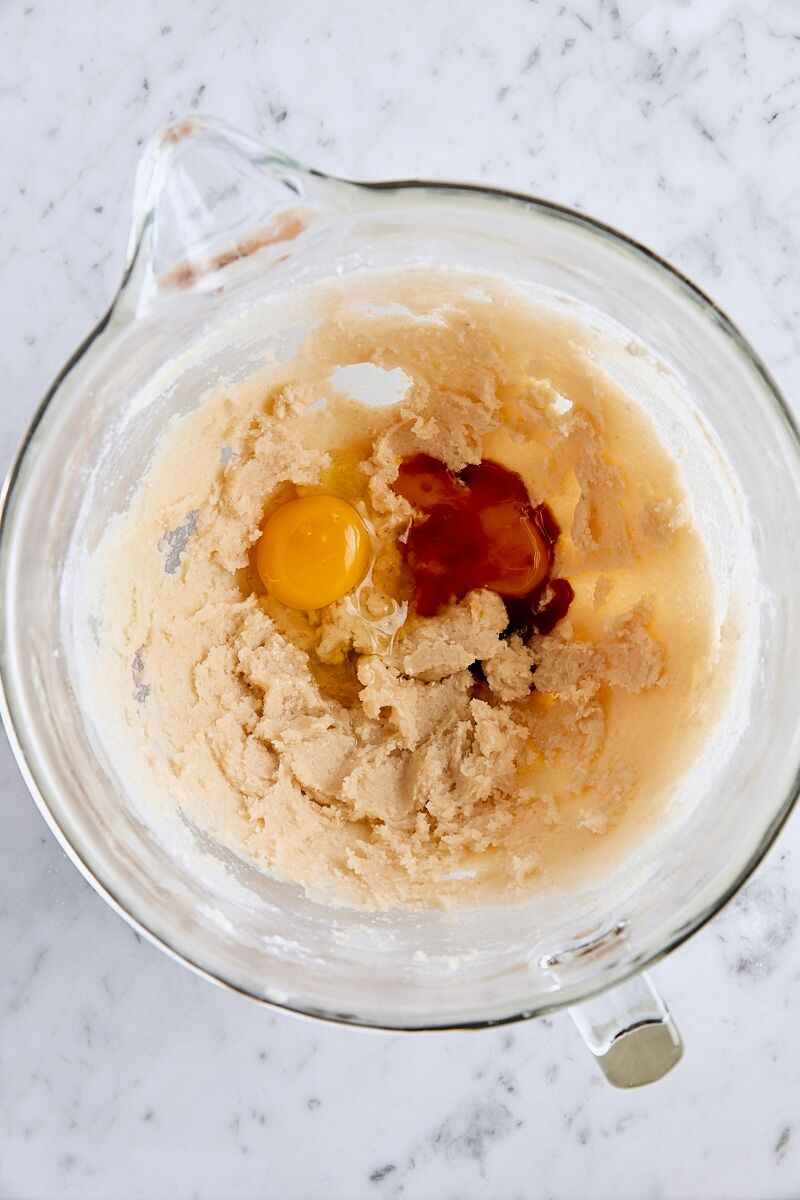 Egg, egg yolk, and vanilla extract added to glass mixer bowl
