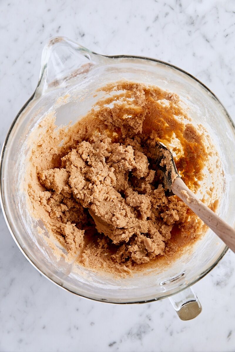 Mixed snickerdoodle bar cookie dough in glass bowl with spatula
